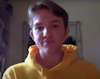 Toby wears a yellow hoodie and looks at the camera.