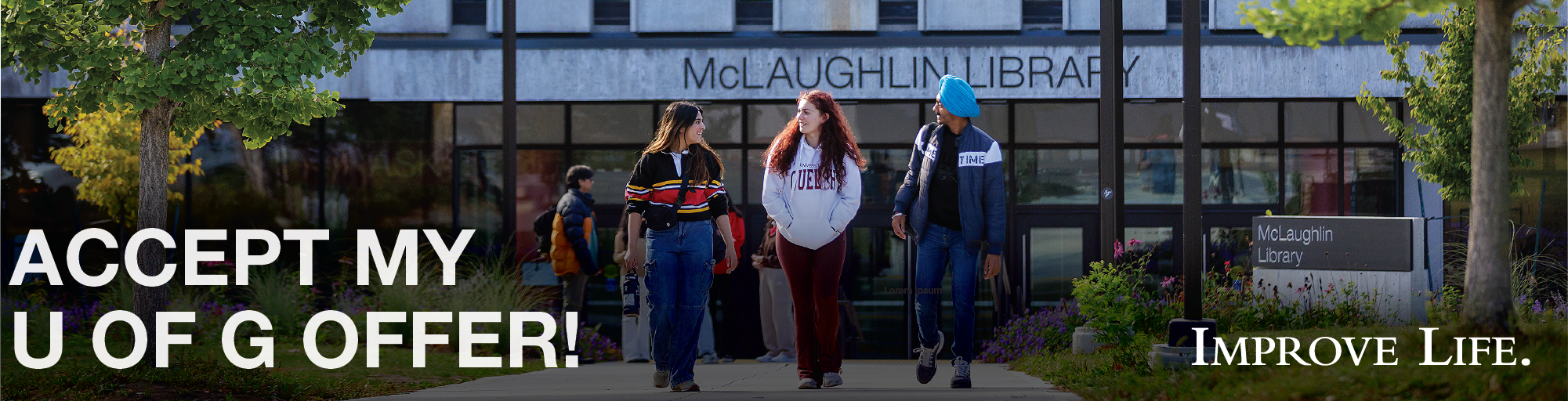 Three students walking in front of McLaughlin Library at the University of Guelph