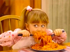 A little girl eating spaghetti.