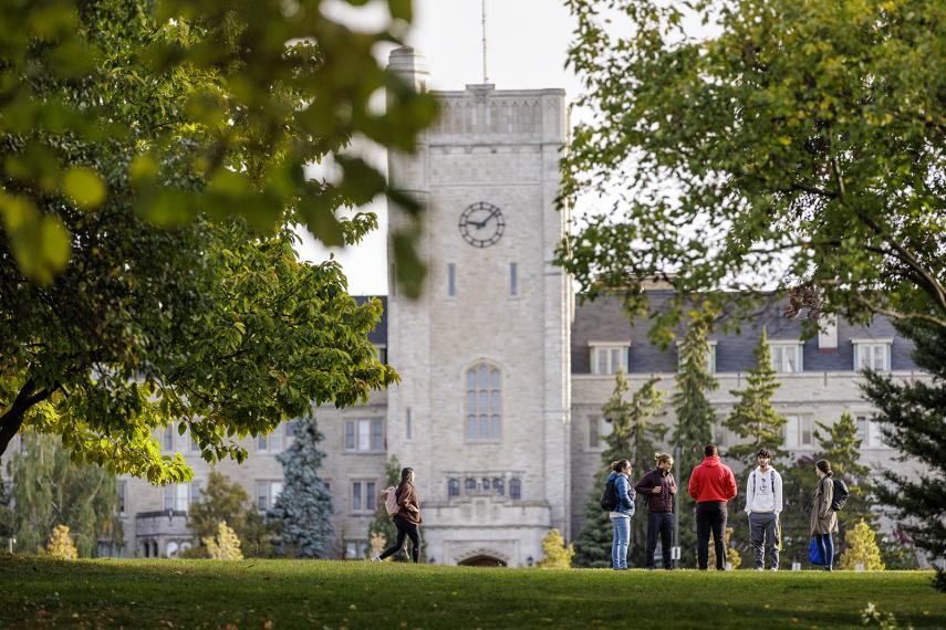 A group of students walking in front of Johnston Hall at the University of Guelph campus.