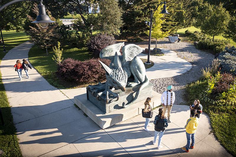 Students congregate around the Gryphon statue on U of G's campus