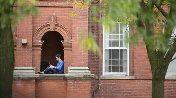 A U of G student with his laptop in a comfy nook on campus.
